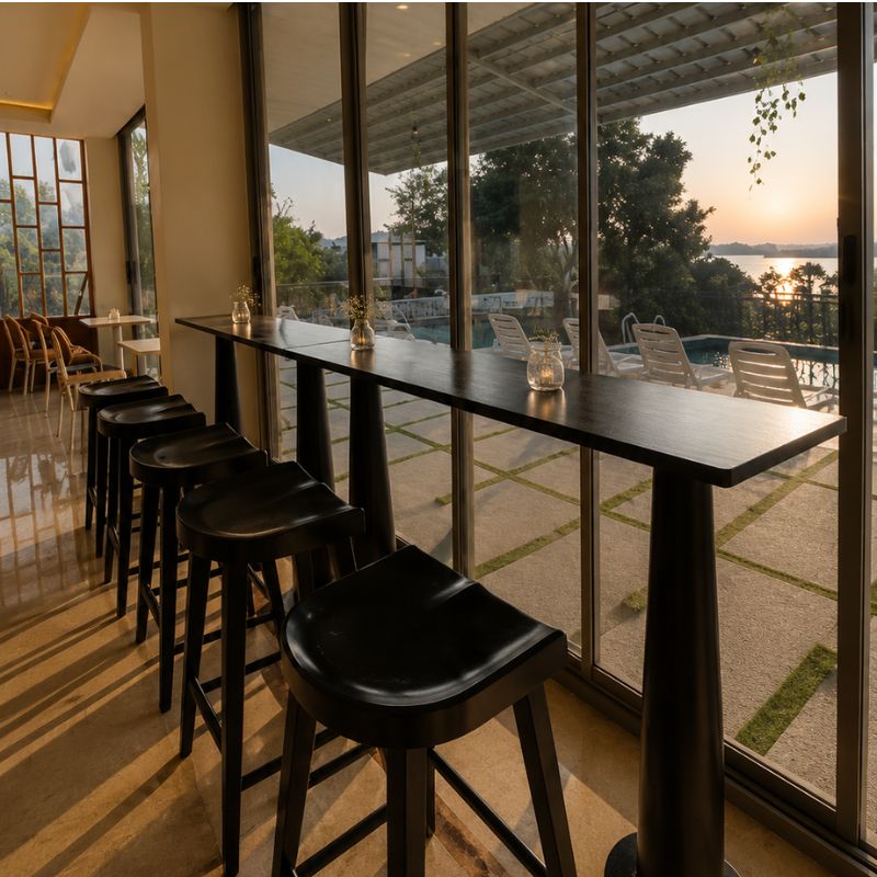 Lakeside Sunset Café Seating at Villa Miraan – Large Group Villa Udaipur High wooden bar counter and black stools facing a sunset lake view at a large group villa with pool Udaipur.